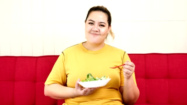 Glückliche-übergewichtige-Frau-genießt-es,-gesundes-Essen-zu-essen