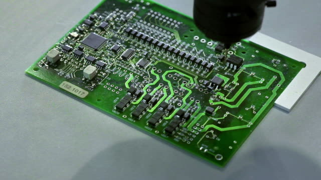 Mechanical-creation-process-of-electronic-circuits.-Creating-an-electronic-board.-Metal-needle-sets-the-chips-on-a-plastic-backing.-Solders-electronic-components.
