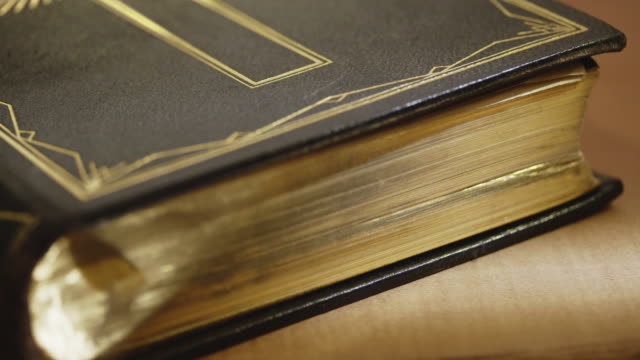 Close-up-of-old-Holy-bible-book,-tracking-shot