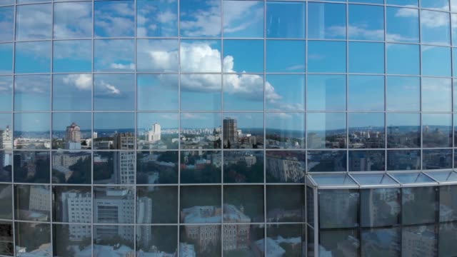 Stadt--und-Blauhimmelreflexion-in-Wolkenkratzer-Fassadenfenstern