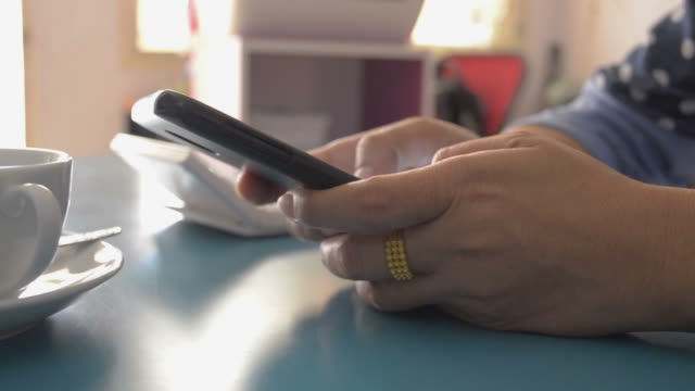 Mujer-usando-el-teléfono-inteligente-en-el-escritorio-en-casa,-escribiendo-mensaje-de-texto.