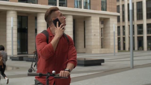 Man-Using-E-scooter-and-Having-Phone-Call