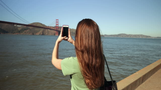 Woman-photographing-the-Golden-Gate-Bridge,-San-Francisco