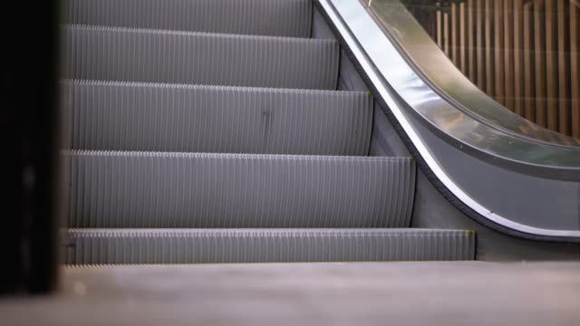 Piernas-de-personas-moviéndose-en-un-ascensor-de-escaleras-mecánicas-en-el-centro-comercial.-Pies-de-comprador-en-Escalera-Saltadora-en-el-Centro-Comercial