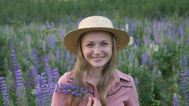 Frau-riecht-Lupinenblumen-verbringen-Zeit-auf-frischer-Wiese