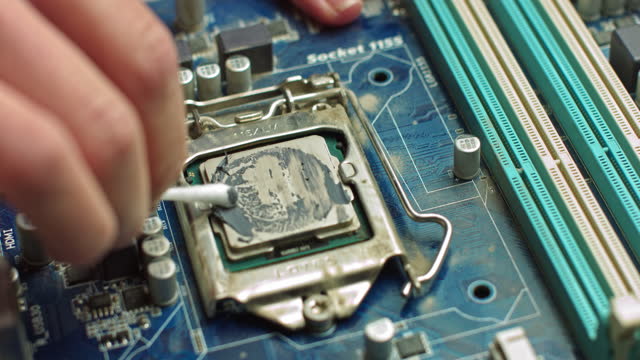 El-reparador-limpia-la-CPU-del-portátil-de-la-grasa-térmica-antigua.-Servicio-de-electrónica-y-conceptos-informáticos.-Reparación-de-placas-de-ordenador