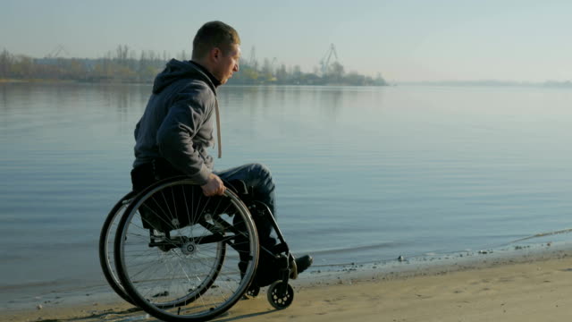 paralizan-en-silla-de-ruedas-cerca-del-río,-movilidad-de-fe-en-el-futuro,-hombre-con