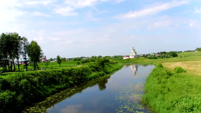 Antena-tiro-río-Kamenka-e-Iglesia-de-la-antigua-ciudad-de-Suzdal,-Rusia