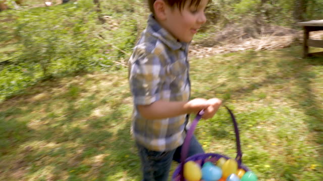 Happy-excited-young-4---5-year-old-boy-holding-a-basket-filled-with-easter-eggs