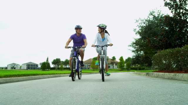 Asian-Chinese-male-female-couple-cycling-outdoors-together