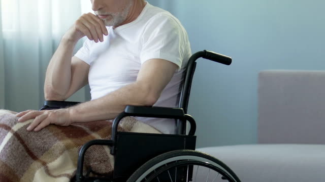 Aged-man-sitting-in-wheelchair-at-nursing-home,-feeling-lonely-and-forgotten