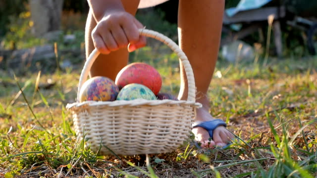 Primer-plano-de-los-niños-tomar-una-cesta-con-huevos-de-Pascua-en-fondo-sol