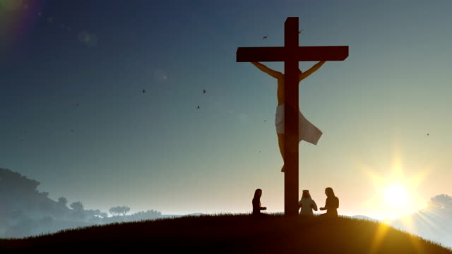 Christians-praying-at-Jesus-cross-at-sunset,-zoom-out