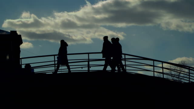 silhouettes-of-people-walk-the-stairs-of-the-stone-bridge,