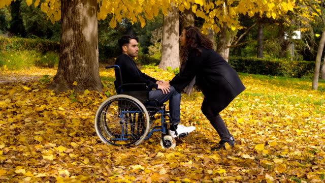 deaktiviert-Man-auf-Rädern-Stuhl-mit-Freundin-im-Herbst-park