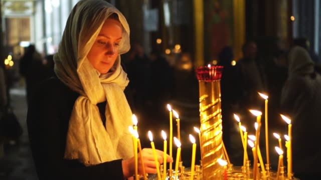 Frau-zündet-die-Kerze-in-der-russisch-orthodoxen-Kirche.