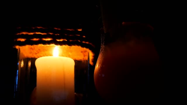 Candle-in-a-restaurant-on-a-black-background-in-a-candlestick-near-the-cocktail,-on-the-beach