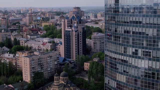 Aerial-view-of-the-glass-skyscraper-in-the-city-and-window-cleaners-washing-the-windows-of-the-skyscraper.-Parus-skyscraper.-Kiev-city.-Ukraine