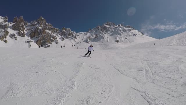 Activo-maduro-esquiador-esquí-abajo-de-las-laderas-de-la-montaña-en-invierno-en-esquí-alpino