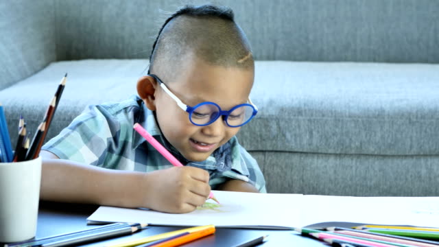 Junge-mit-Behinderung,-Störungen-des-Gehirns-und-linkes-Auge-ist-nicht-sichtbar-von-Gehirnchirurgie.-Spaß-haben,-genießen-Sie-zeichnen-oder-schreiben-im-Buch-zu-Hause.