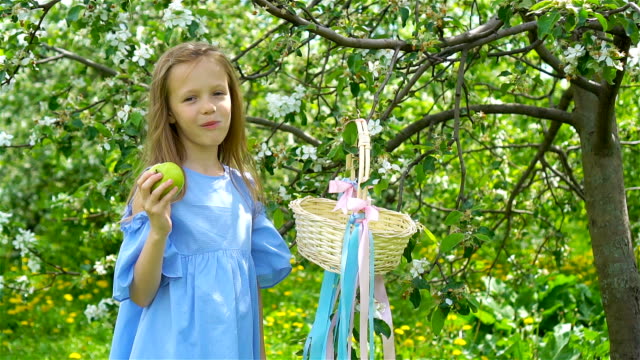 Entzückende-kleine-Mädchen-in-blühender-Apfelgarten-an-schönen-Frühlingstag