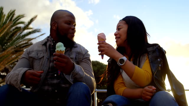 Disabled-woman-feeding-ice-cream-to-man-on-a-sunny-day-4k