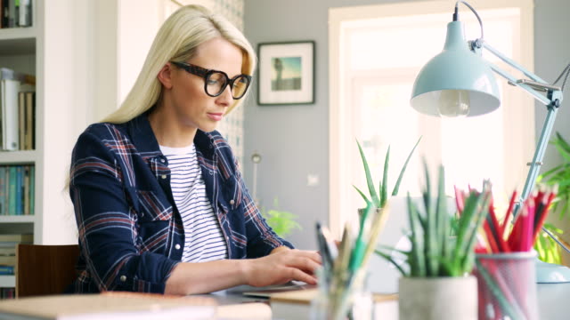 Attraktive-blonde-Geschäftsfrau-Tippen-auf-Laptop-zu-Hause-Büro
