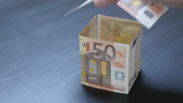 European-Union-currency-investing-in-real-estate-metaphor-4K-2160p-30fps-UHD-video---House-shaped-of-50-Euro-banknotes-money-concept-4K-3840X2160-UltraHD-footage