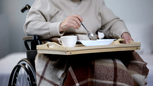 Señora-con-discapacidad-a-regañadientes-cenando-en-centro-médico,-cuidado-inadecuado