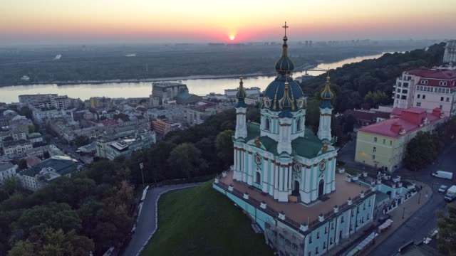 Kyiv,-Ukraine.-Flying-over-St.-Andrew's-Church-on-the-bank-of-Dnieper-River-during-sunrise.-Aerial-shot,-4K