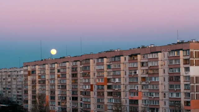 Big-Full-Moon-above-the-Roof-of-a-Multistory-Building-is-moving-up