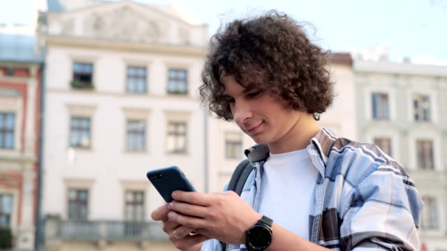Man-textet-mit-App-auf-Smartphone-in-der-Stadt.-Tourist-oder-Student,-Chats-oder-Texte-auf-dem-Smartphone,-Aufenthalte-mit-Freunden-oder-Familie