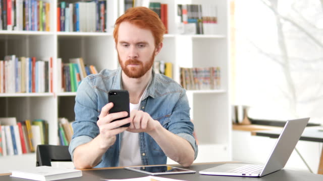 Gelegenheits-Redhead-Mann-mit-Internet-auf-Smartphone
