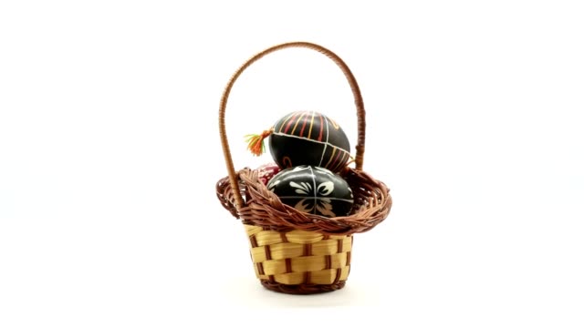 decorative-basket-with-painted-Easter-eggs-on-white-background