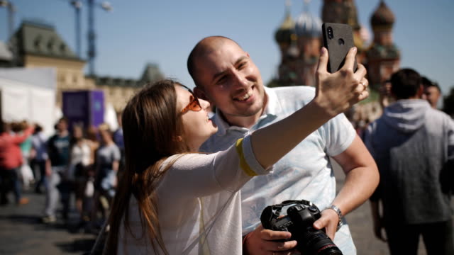Pareja-joven-tomando-auto-retrato-selfie-foto-en-la-plaza-roja-en-Moscú.