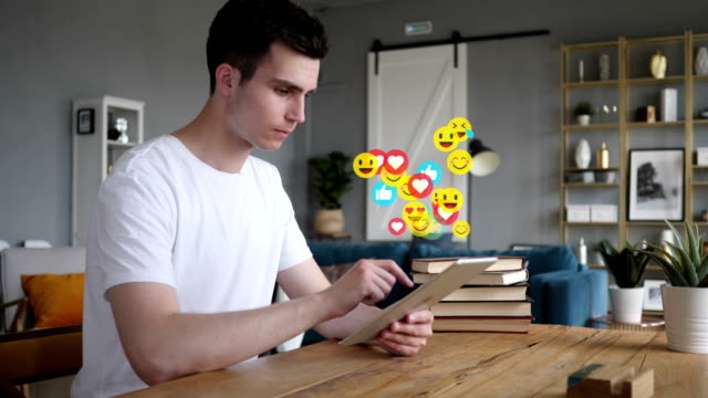 Happy-Young-Man-Using-Tablet,-Flying-Emojis,-Smileys-and-Likes