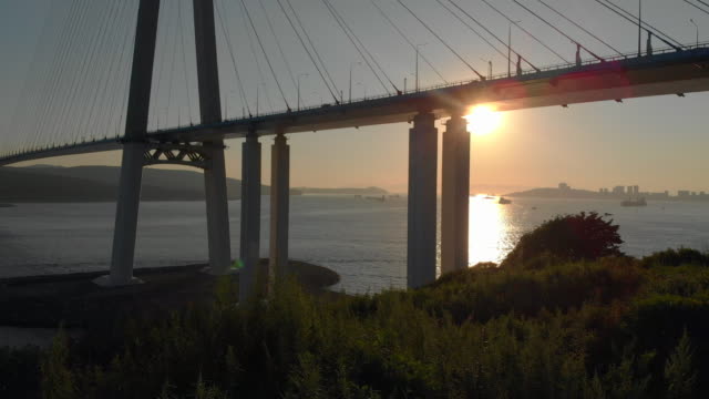 Aerial-shot-of-the-Russkiy-cable-bridge-during-sunset-in-a-city-of-Vladivostok,-Russia
