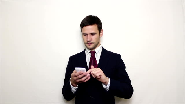 El-joven-y-guapo-hombre-de-negocios-está-viendo-una-señal-de-noticias-en-su-teléfono-inteligente.