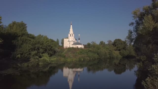 Vuelo-sobre-el-río-y-hermosa-iglesia-en-Suzdal.-Rusia.-Vista-aérea-desde-drones