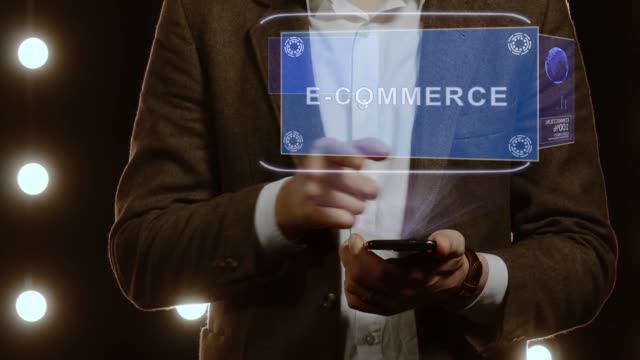 Businessman-shows-hologram-with-text-E-commerce