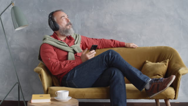 Man-Enjoying-Music-through-Headphones-and-Resting