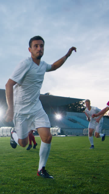 Professional-Soccer-Player-Outruns-Members-of-Opposing-Team-and-Kicks-Ball-and-Scores-Goal.-His-Team-Celebrates-Victory.-Video-Footage-with-Vertical-Screen-Orientation