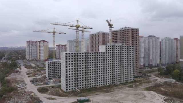 4k-Luftbild-große-Baukräne-und-unfertige-Häuser