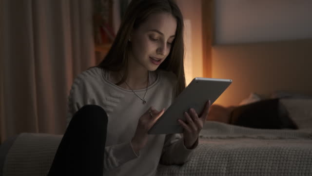 Adolescente-chica-usando-tableta-digital-a-altas-horas-de-la-noche-en-el-dormitorio