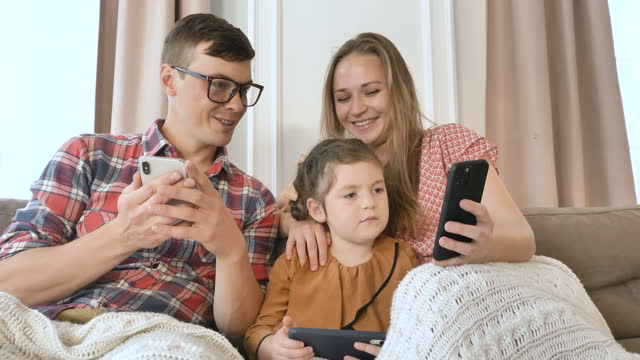 Familie-von-Mutter-Vater-und-Tochter-verwenden-verschiedene-Gadgets