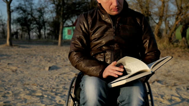 Disabled-man-reads-bible,-faith-in-god,-faith-in-future,-wheelchair,-man