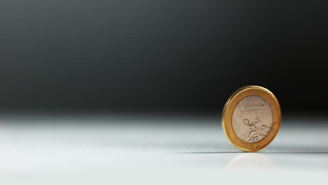 Coin-of-1-Euro-Rolling-against-White-Background,-Slow-motion-4K