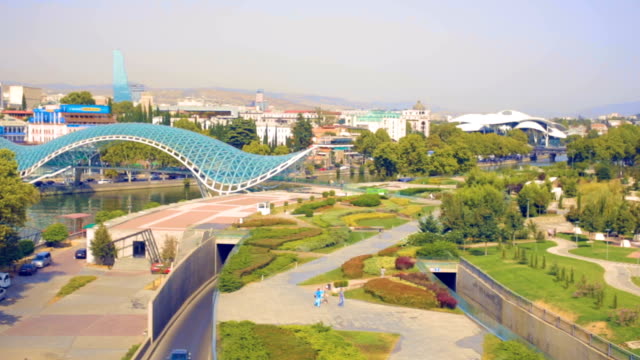 Tiflis-(Tbilissi),-Georgien-Hauptstadt-Georgiens.-Luftaufnahme-des-Zentrum-von-Tiflis,-Brücke-des-Friedens-über-Fluss-Kura.-Kamera-fliegt-die-Drohne-über-Stadt.