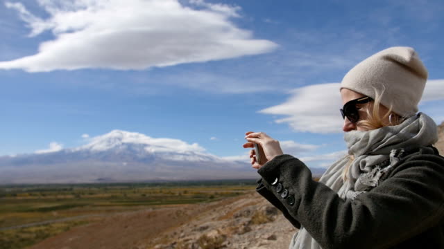 Urlaub-Reisen-Frau-nehmen-Fotos-von-Ararat-Berglandschaft.-Natur-in-den-Sommerferien.-Junge-Frauen-stehen-bei-Lookout-und-machen-Sie-Aufnahmen-auf-ihrem-Mobiltelefon.