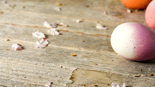 Huevos-de-Pascua-panorámica,-antigua-mesa-de-madera-y-pétalos-de-flor-de-almendra